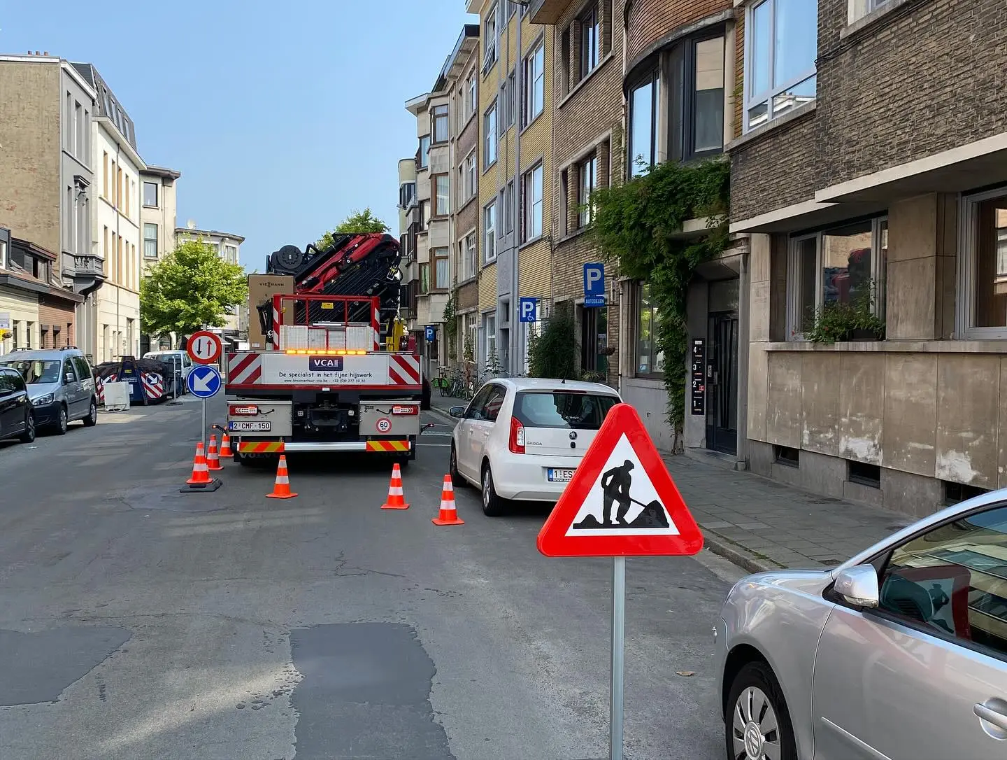 Werfsignalisatie van Kraanverhuur VCA in een Antwerpse straat: werfbord, pijlborden en verkeerskegels rond de autolaadkraan