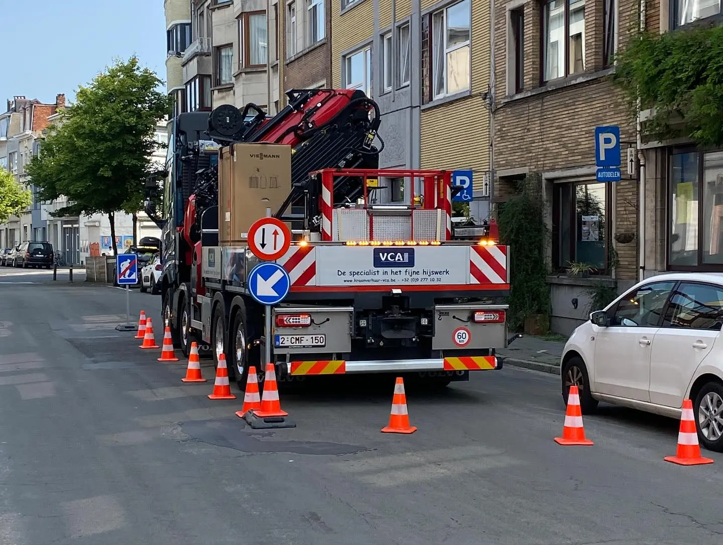 Afgezette werfzone met verkeerskegels en pijlborden rond een opgestelde autolaadkraan